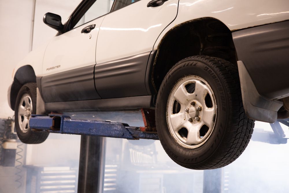 SUV raised on a two-post lift in the shop